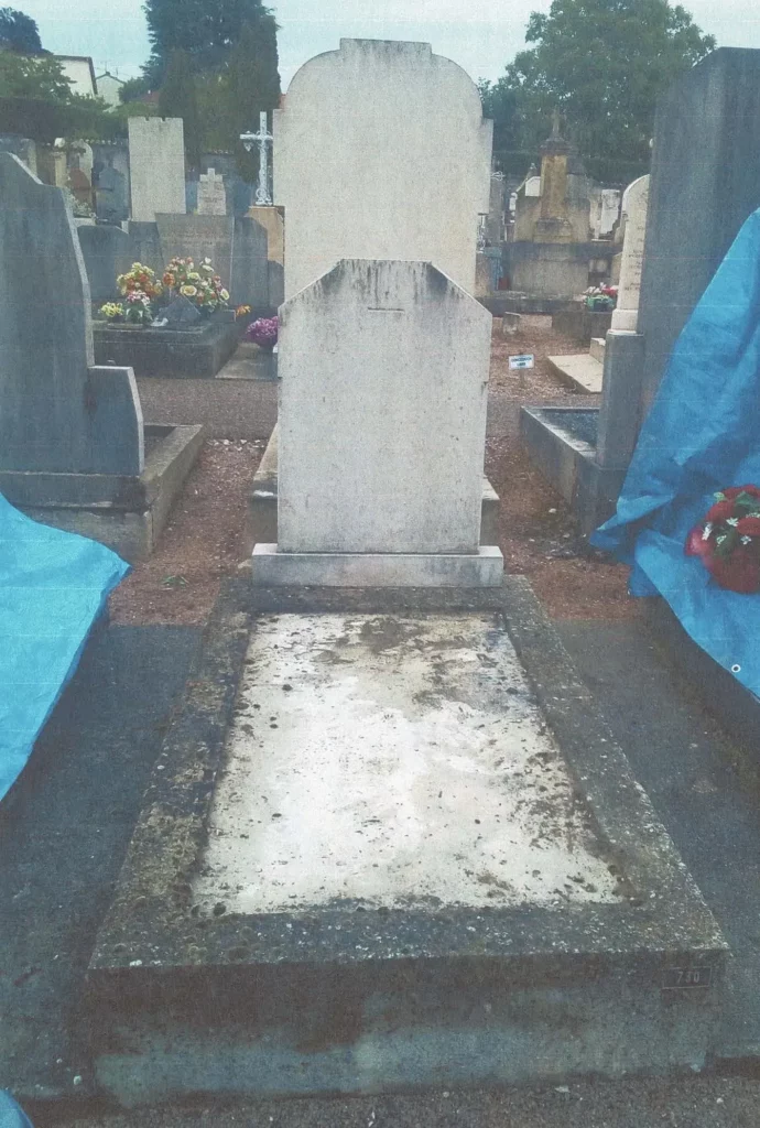 Ancienne tombe en pierre en cours de rénovation dans un cimetière.