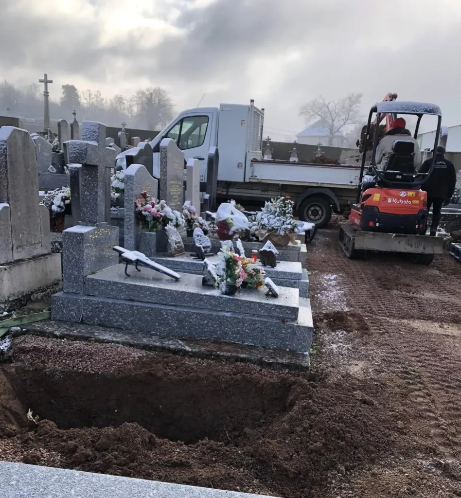 Sépultures enneigées et travaux de terrassement dans un cimetière.