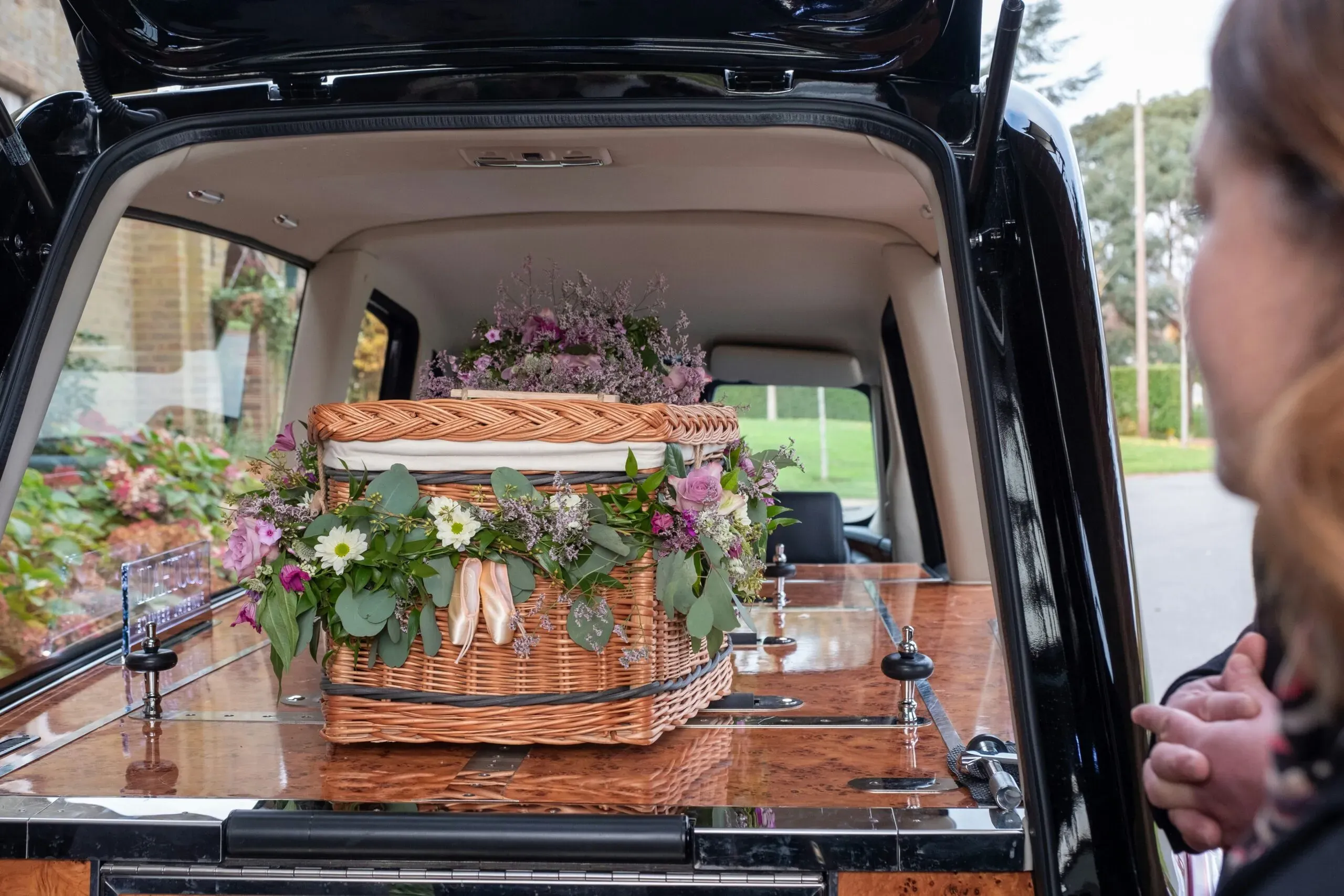 Cercueil en osier tressé orné de fleurs dans un corbillard
