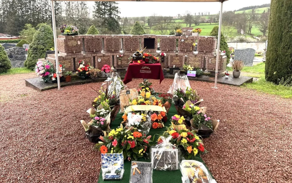 Espace funéraire avec columbarium et nombreuses fleurs d'hommage